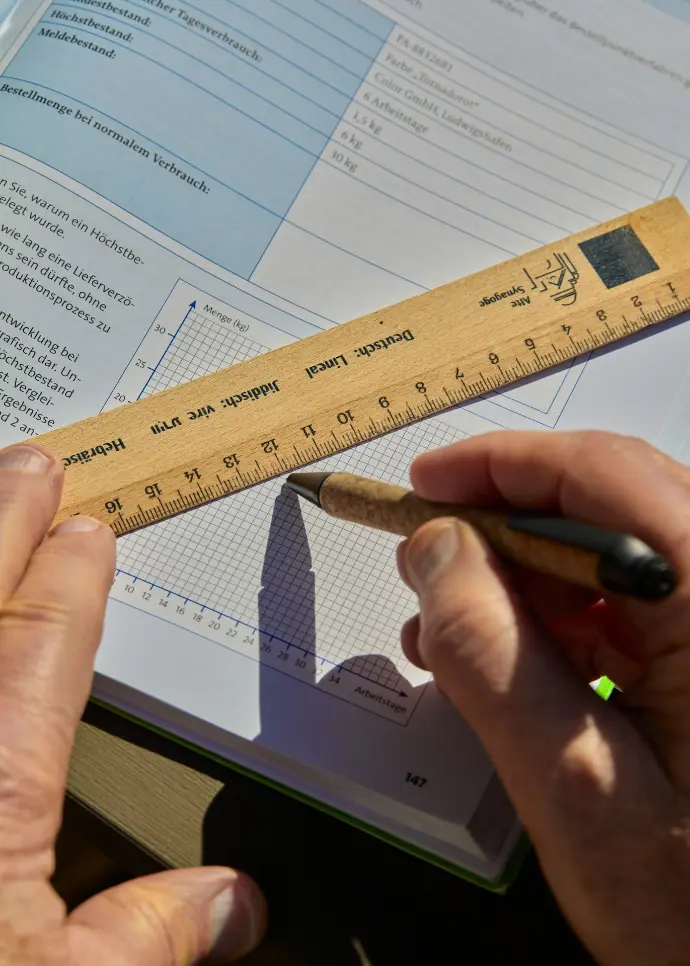 Someone is drawing a graph with a ruler and pen.